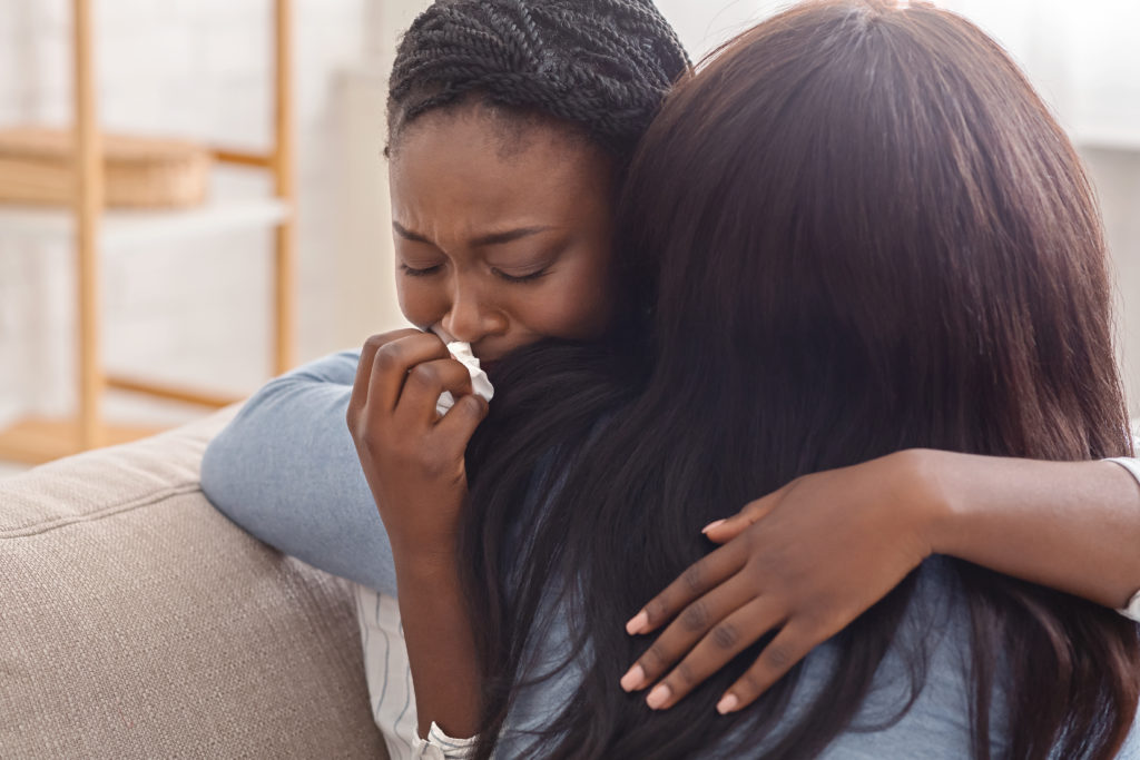 Friend comforts Black woman after receiving bad news