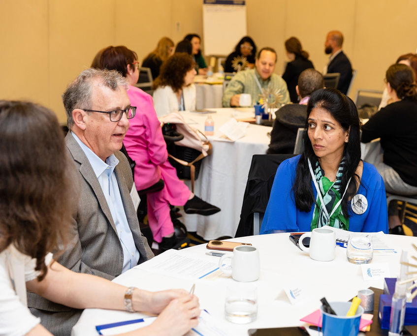Individuals talk at a table during the Quality of Life Roundtable hosted by the National Brain Tumor Society.