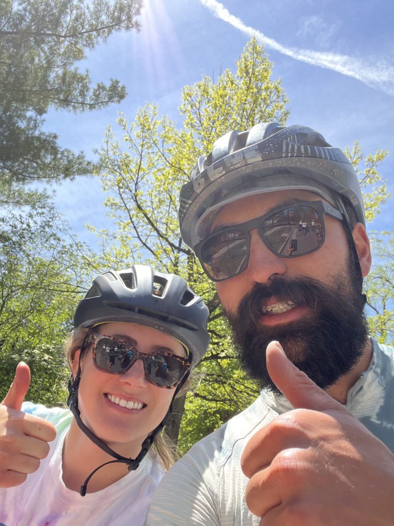A woman and man give a thumbs up while wearing bike helmets and sunglasses during the Denver National Brain Tumor Ride.