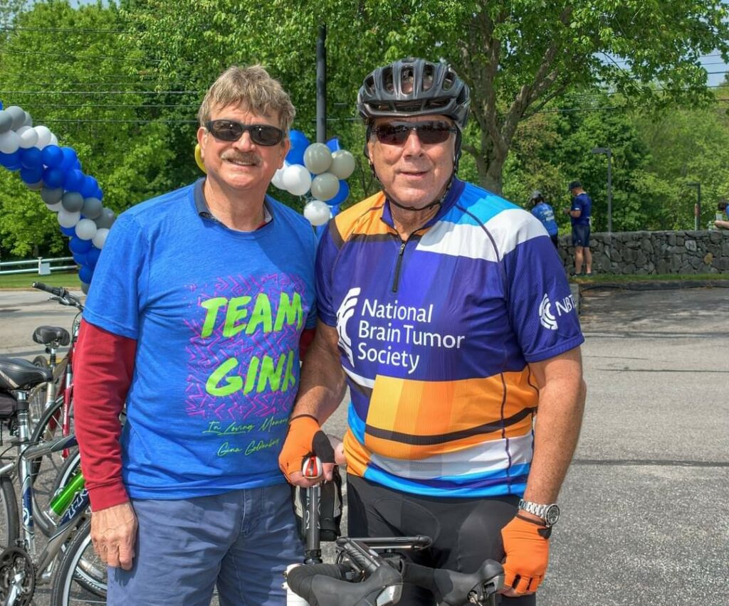 Two men stand next to a bike at the 2023 National Brain Tumor Ride.