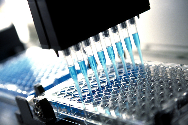 Robotic multichannel pipette device portions out blue fluid for medical and pharmaceutical research and testing like the MGMT promoter methylation test.