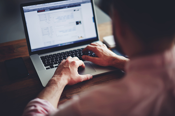 Cropped image of a young man working on his Social Security Disability Insurance application on his laptop 