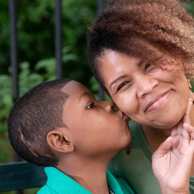 Kai and his mom embrace at a nearby playground.