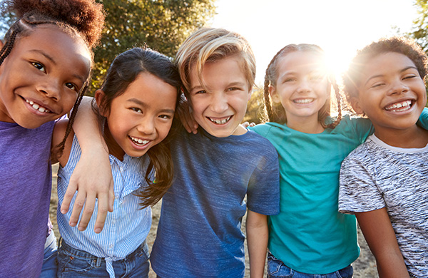 Portrait Of Multi-Cultural Children Hanging Out With Friends In Countryside Together