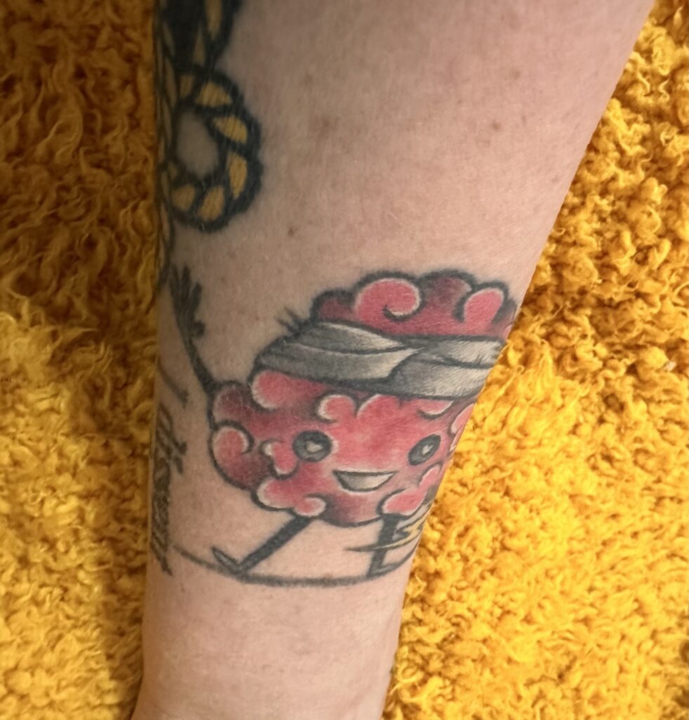 Stacy shares one of her tattoos, which is a colorful brain with arms and feet along with a lightning bolt and a head bandage.