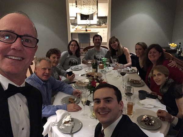 A group of people in black-tie dress smile around a dinner table. Support of friends helped Lisa while navigating the holidays as a caregiver.