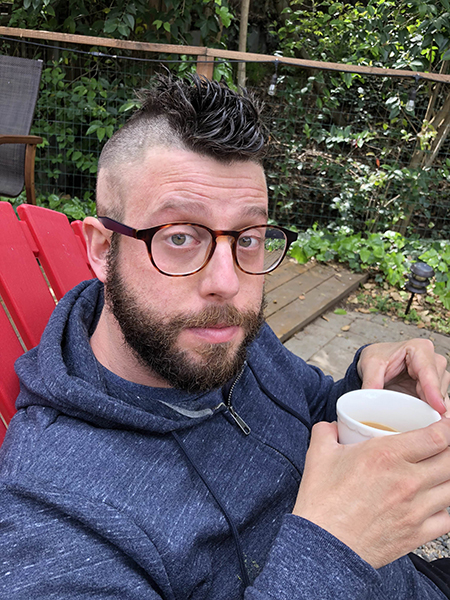 A man with a mohawk due to radiation treatment holds a mug. He secured treatment through an expanded access program.