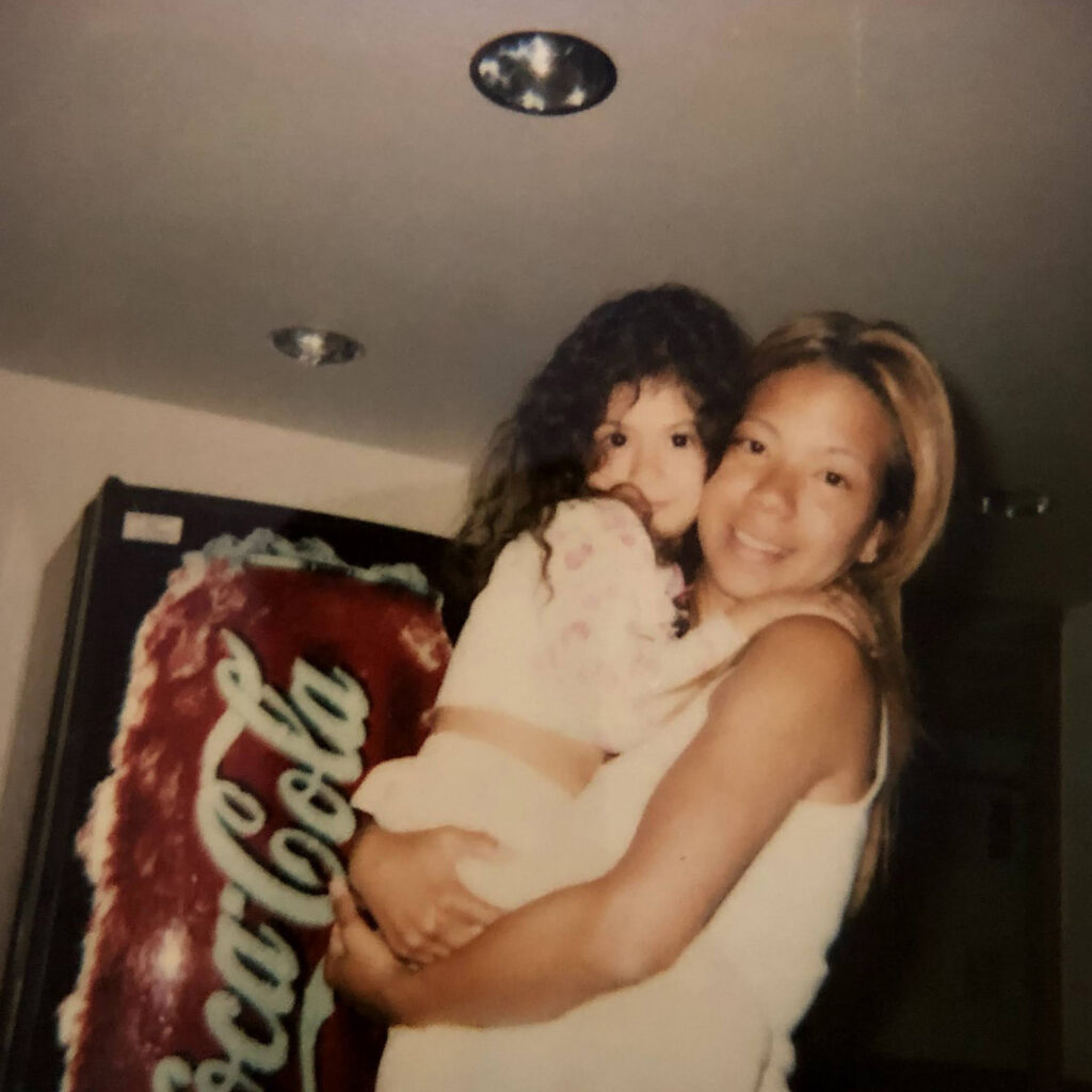 A woman holds her 5-year-old daughter in her arms.