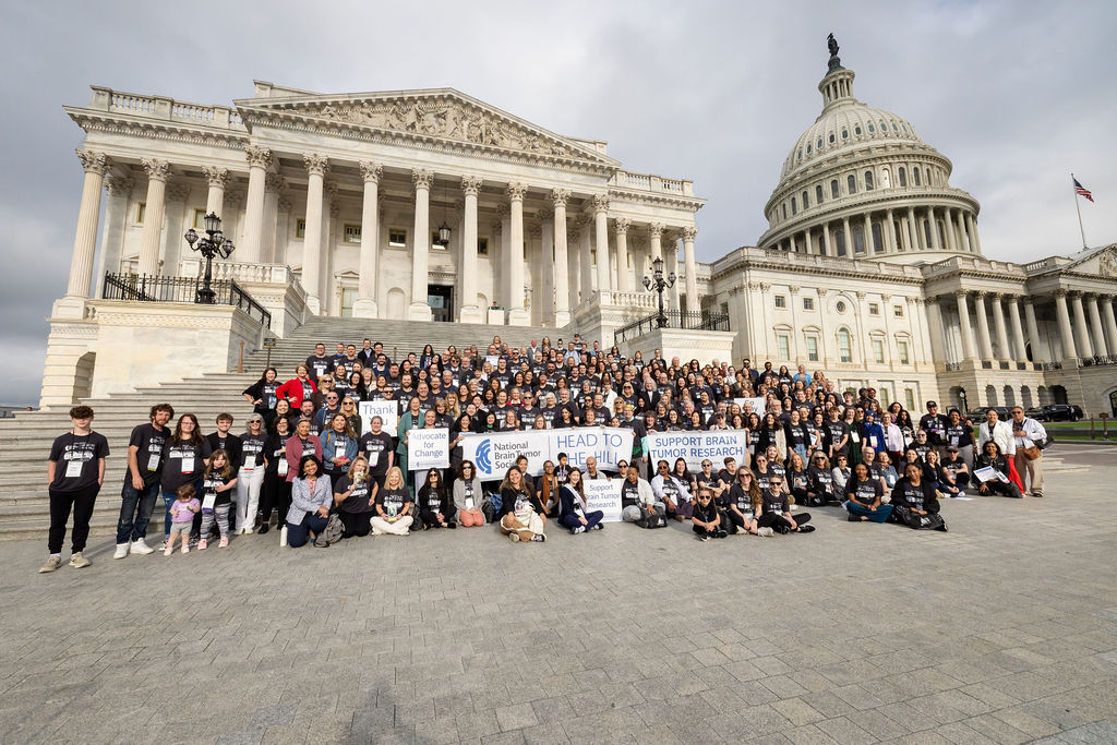 A group of brain tumor advocates stand on the steps of the U.S. Capitol with their Head to the Hill signs.