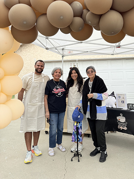 A young adult man, elderly woman, a young adult woman, and an older woman stand below brown balloons. They found community through NBTS after the woman on the right was diagnosed with glioblastoma.