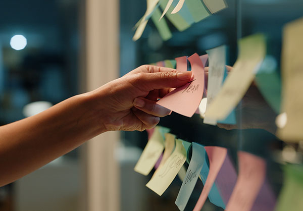 Hand, business and sticky note with planning to help employee returning to work after a brain tumor diagnosis