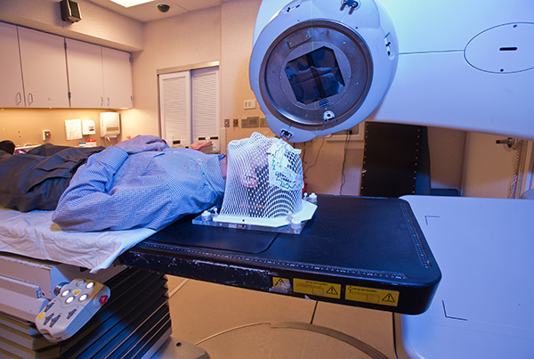 Patient lying under a linear accelerator or linac for cancer radiation therapy.