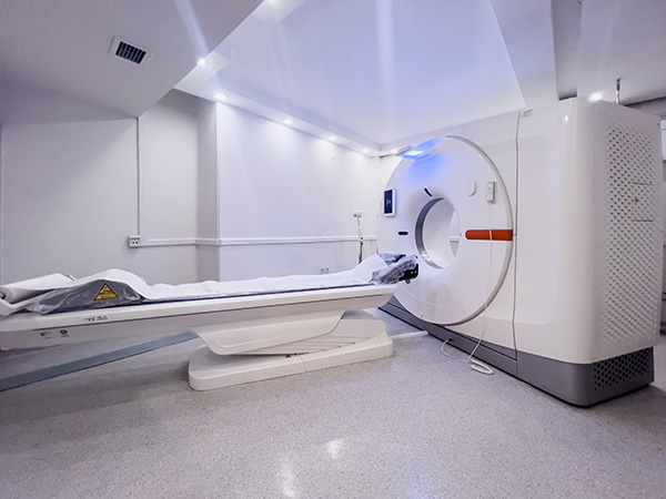 A high-resolution, well-lit photo of a modern MRI machine in a clean, sterile hospital room—captured with sharp detail, balanced lighting, and a wide-angle perspective to emphasize space and technology.
