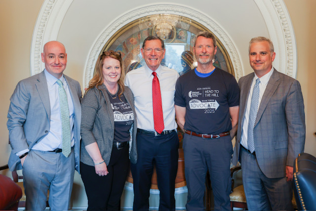 Five people stand together as they advocate for the BRAIN Act. The man in the middle is Sen. Barrasso. He is flanked by brain tumor advocates and supporters.