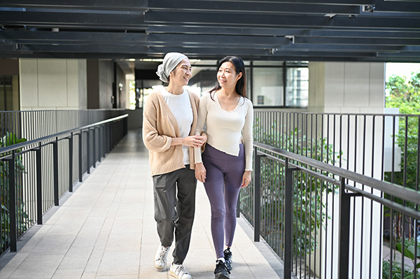Two friends share laughter and stories as they stroll arm in arm, their bond shining through every happy conversation and carefree step.