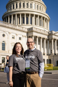 A teenage daughter and her father stand in front of the Capitol wearing Head to the Hill t-shirts.