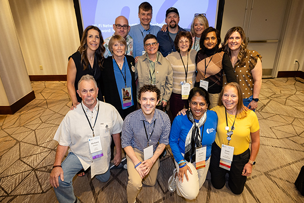 A group of 14 brain tumor research advocates and one NBTS staff member pose for a photo at an event.