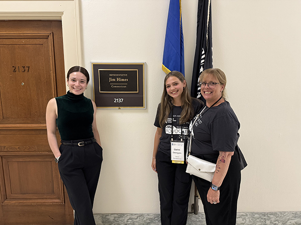 A teenage girl, who is a JPA survivor, stands next to her mom in front of Representative Jim Hines' office during Head to the Hill as pediatric brain tumor advocates.